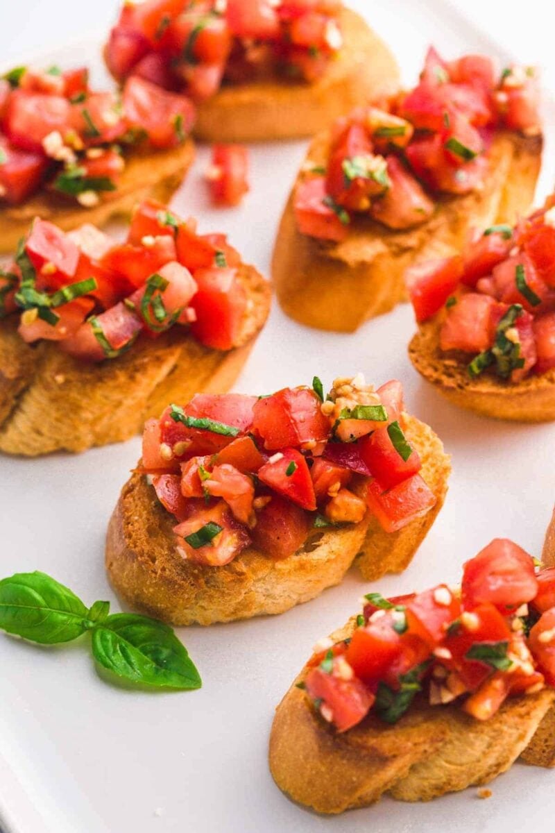 Bruschetta is an easy Italian appetizer made with bread that is grilled then rubbed with cloves of garlic. It is often topped with olive oil, juicy and bright tomatoes, and fresh basil leaves. A quick appetizer that you can throw together in just 20 minutes!