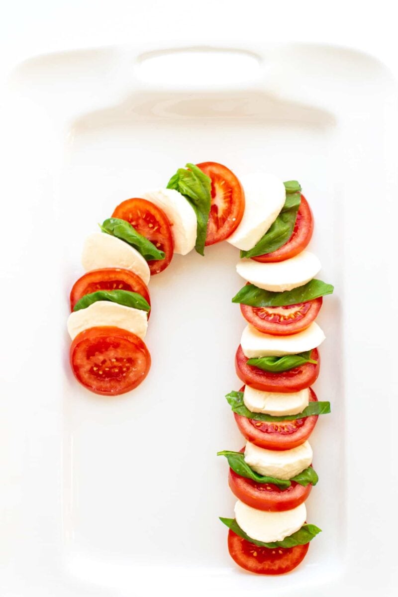 This Christmas Caprese Salad consists of tomatoes, bocconcini and fresh basil arranged in the shape of a candy cane. A delicious, simple salad that will add a fun, festive touch to your holiday table!