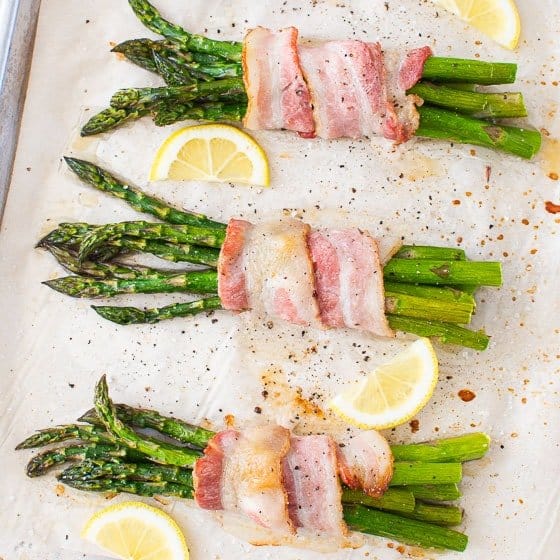 This easy Bacon Wrapped Asparagus bundles are oven roasted in under 30 minutes, until crispy, tender, and juicy. When finished with a drizzle of lemon juice and a sprinkling of salt, these low carb appetizers are irresistible!