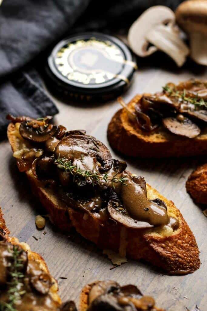 These festive vegan mushroom crostini recipe is an easy and impressive appetizer perfect for holidays. Crunchy baguette with grilled vegan mozzarella topped with sweet caramelized onions and mushrooms with a hint of balsamic and Dijon mustard will surely be a show stopper.