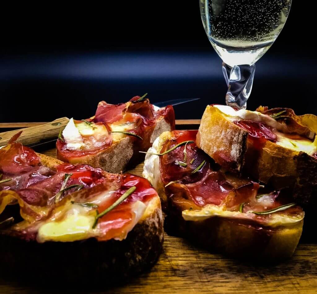 This Crostini with Brie, Coppa and Raspberry is an elegant appetizer, the basic ingredients for which can go a long way if prepping for a crowd. Crostini itself can be made with hundreds of ingredient combinations, the foundations being a baton of crusty bread and some type of cheese. I have opted for a sweet and savory crostini for Christmas!