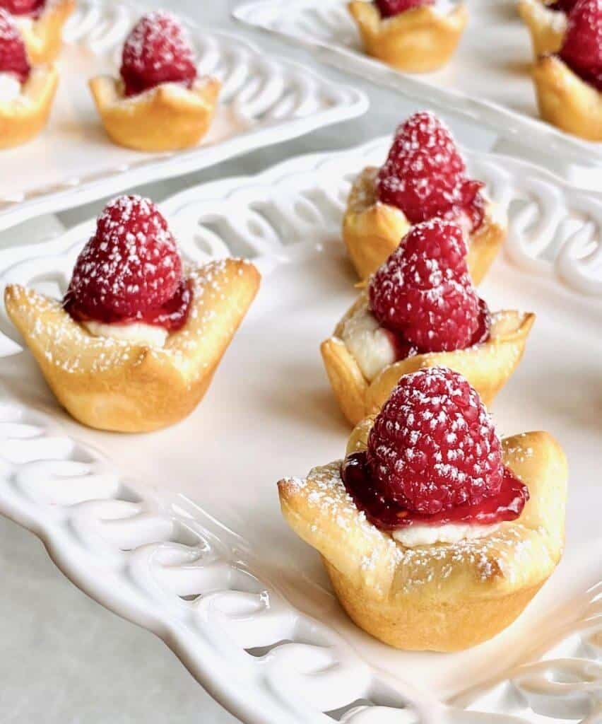 Raspberry Goat Cheese Bites are sweet and savory appetizers made with crescent rolls, pesto goat cheese, raspberry jam, and fresh raspberries. They're an impressive and easy finger food!