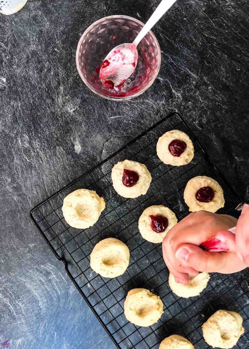 Pipe the raspberry jam onto the cookies.