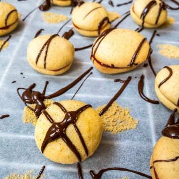 Egg yolk cookies, assembled with strawberry jam and drizzled with dark chocolate couverture.