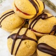 Egg yolk cookies, assembled with strawberry jam and drizzled with dark chocolate couverture.