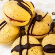 Egg yolk cookies, assembled with strawberry jam and drizzled with dark chocolate couverture.