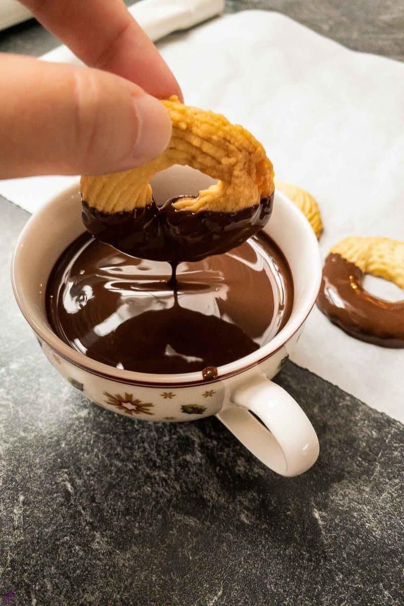 Dip cooled butter cookies in melted dark chocolate couverture. 