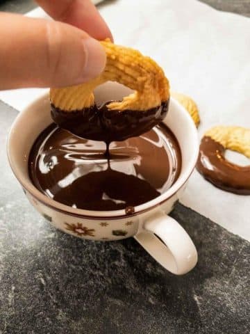 Dip cooled butter cookies in melted dark chocolate couverture.