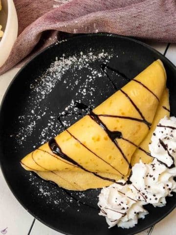 Thin pancake dough, filled with delicious vanilla bean ice cream, drizzled with chocolate sauce, and refined with whipped cream and chocolate sprinkles!