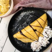 Thin pancake dough, filled with delicious vanilla bean ice cream, drizzled with chocolate sauce, and refined with whipped cream and chocolate sprinkles!