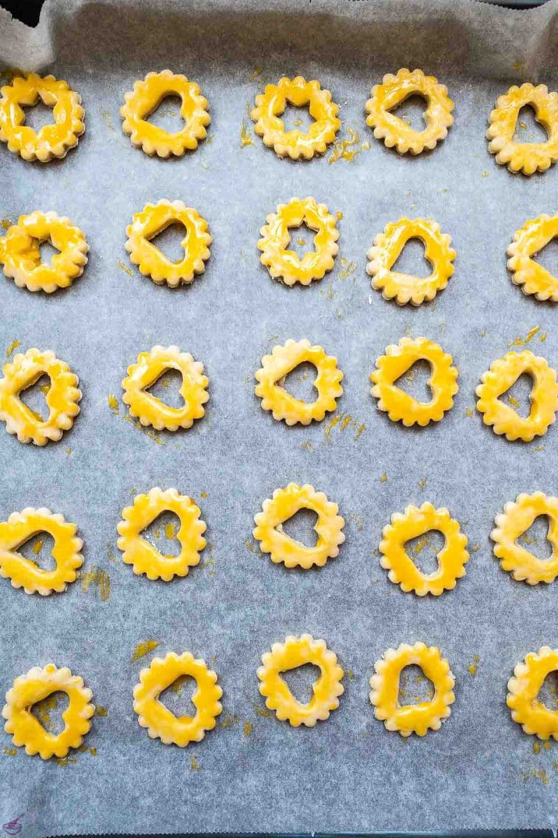 Cut out sour cream cookies before baking. Spread with egg yolk. 