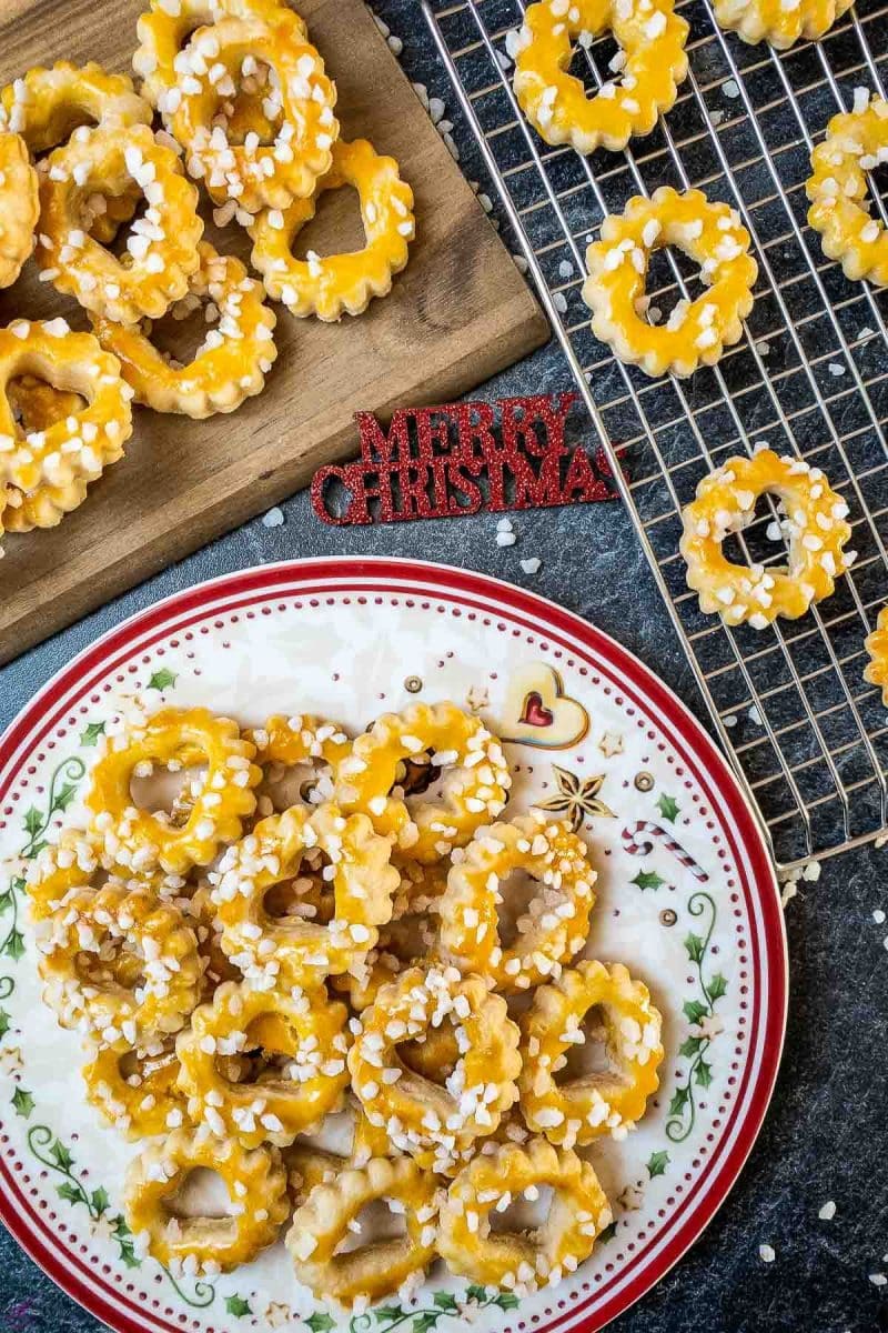 Cut out sour cream cookies after baking. Spread with egg yolk and sprinkled with nib sugar. 