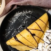 Thin pancake dough, filled with delicious vanilla bean ice cream, drizzled with chocolate sauce, and refined with whipped cream and chocolate sprinkles!