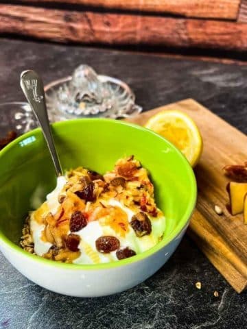 Breakfast bowl with grated apples, raisins, yogurt, honey and rolled oats.