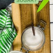 Adding vanilla bean to preserving jar filled with granulated sugar.