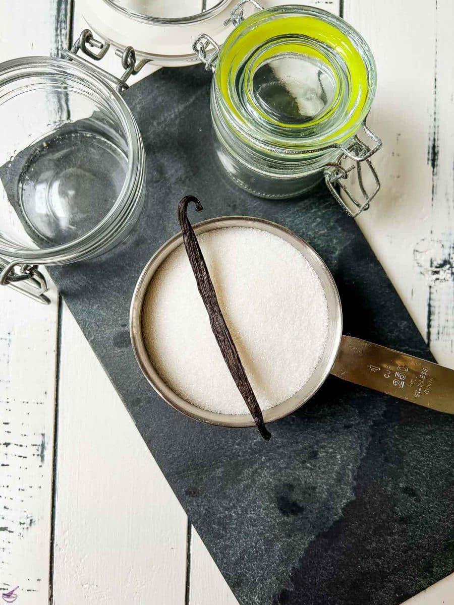 1 cup sugar with a vanilla bean on a black stone board. 