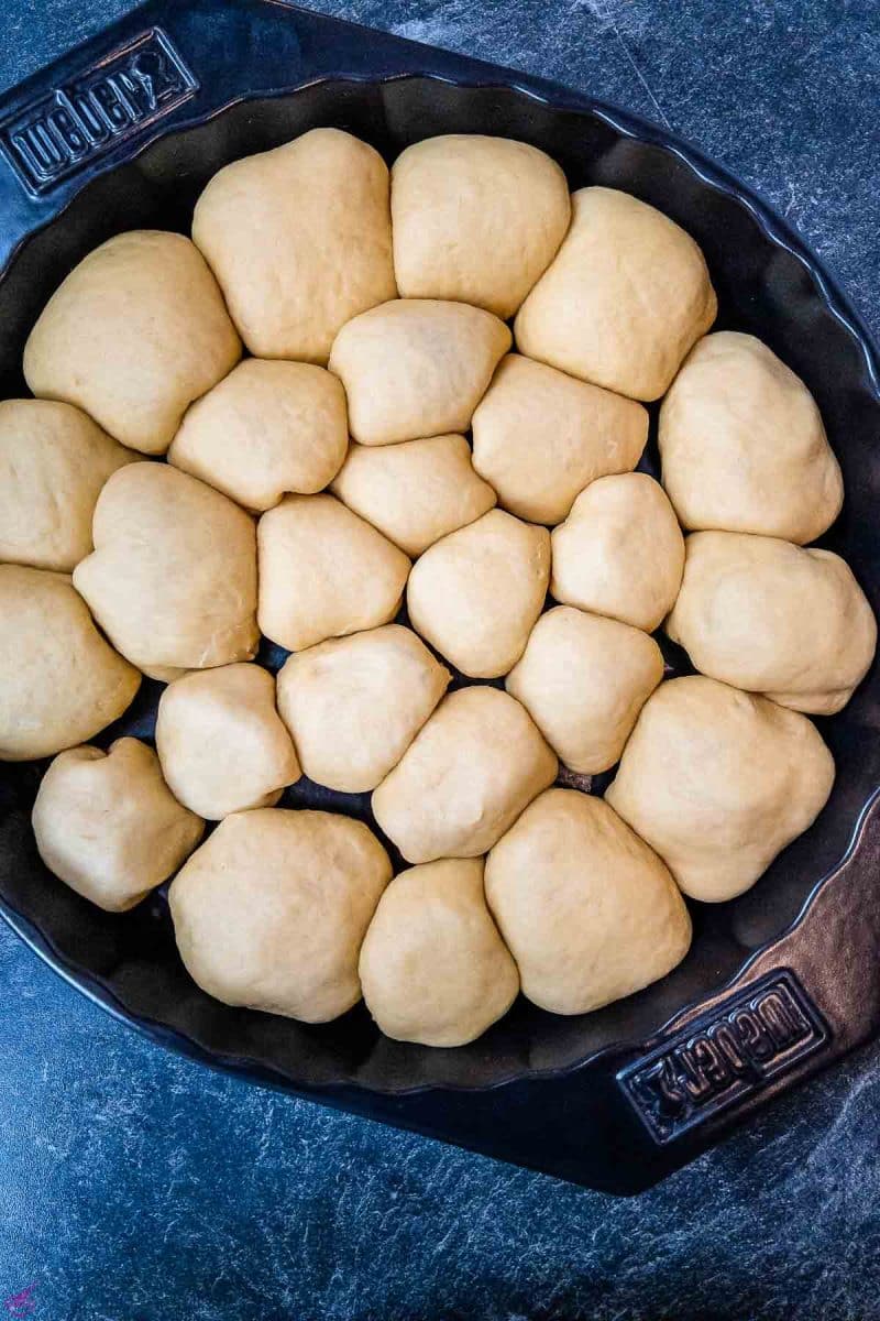 Finished, filled Buchtel, end down, in the prepared pan. Prior baking. 