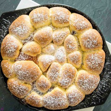 Finished baked Buchteln sprinkled with powdered sugar and ready to be eaten.