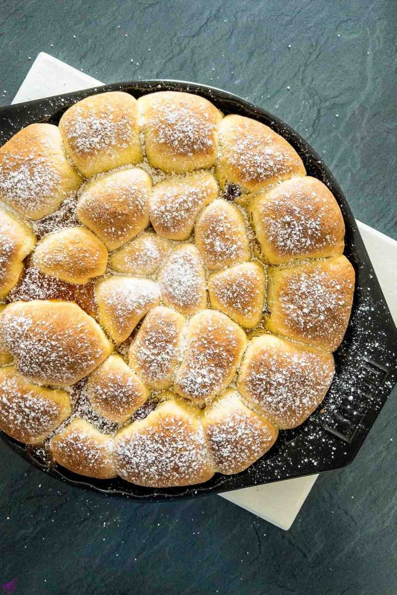 Finished baked Buchteln sprinkled with powdered sugar and ready to be eaten.