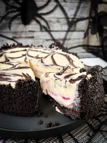 Slice of no bake raspberry Oreo cheesecake on a black plate.