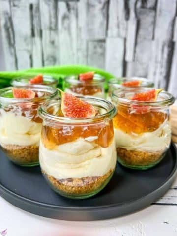 Ready prepared layer dessert. Fig cheesecake without baking with cream cheese filling, cookie base and fig preserve on top.