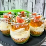 Ready prepared layer dessert. Fig cheesecake without baking with cream cheese filling, cookie base and fig preserve on top.
