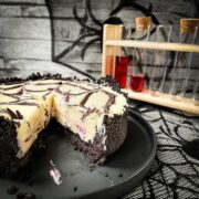 Slice of no bake raspberry Oreo cheesecake on a black plate.