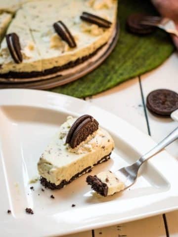 A refreshing green no bake mint chocolate cheesecake with Oreo crust and After Eight pieces inside the cream cheese filling.