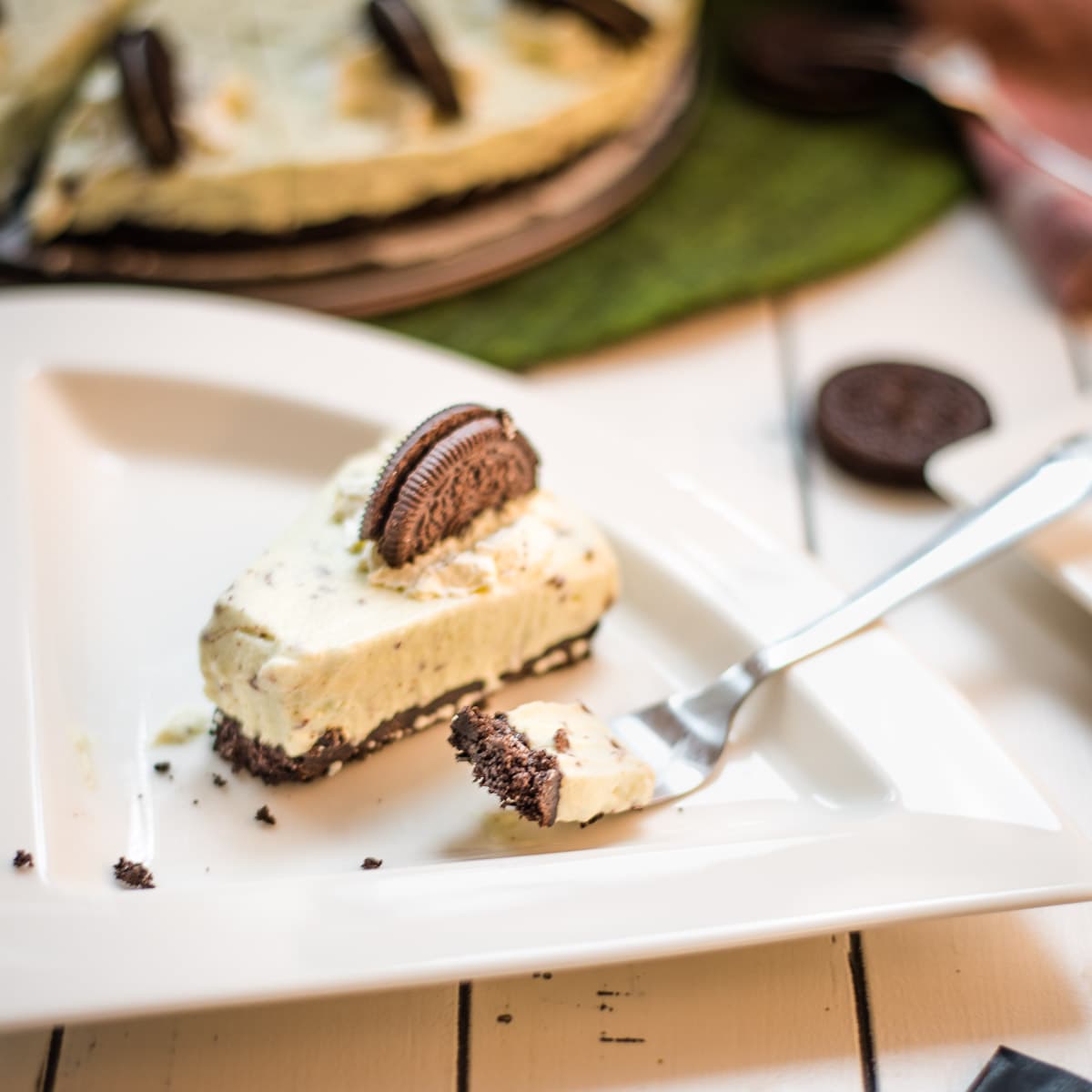 A refreshing green no bake mint chocolate cheesecake with Oreo crust and After Eight pieces inside the cream cheese filling.