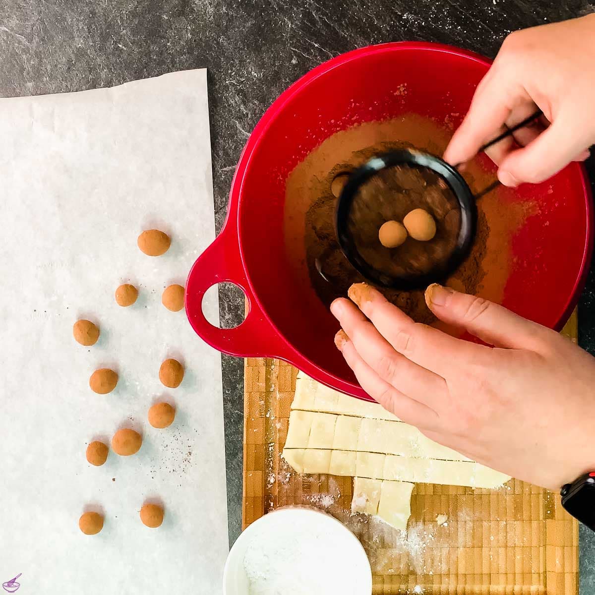 Roll the cocoa covered marzipan potatoes in a sieve to remove the excess cocoa.