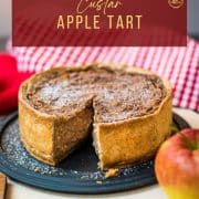 Delicious apple tart with a slice cut out. Dusted with powdered sugar.