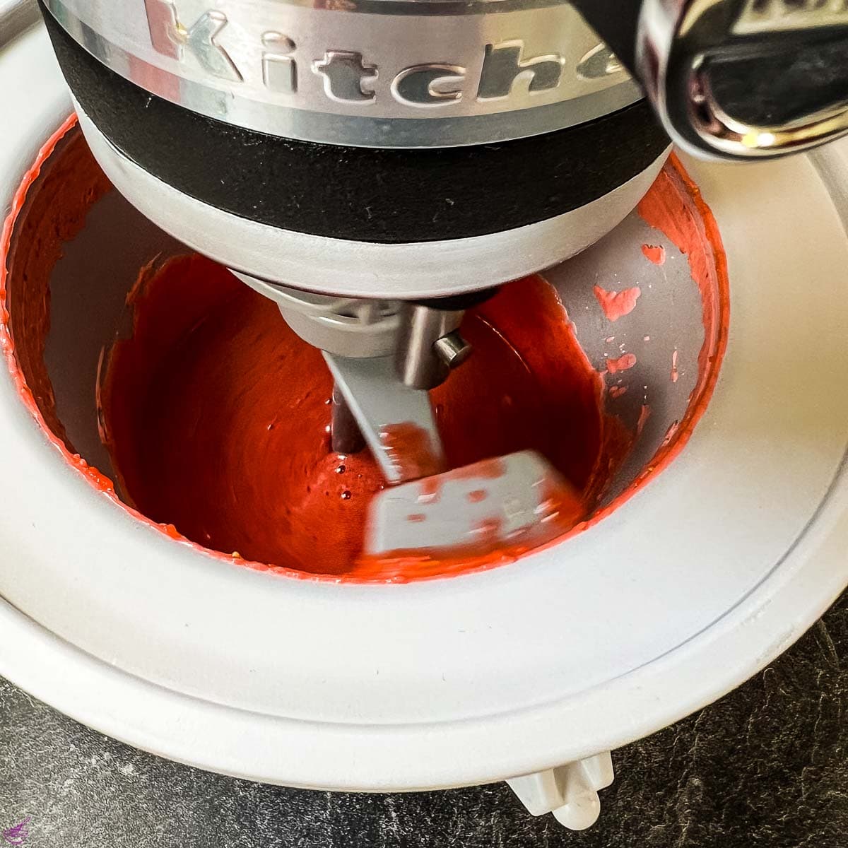 Ice cream maker filled with strawberry mixture, freezing the strawberry purée into ice cream.