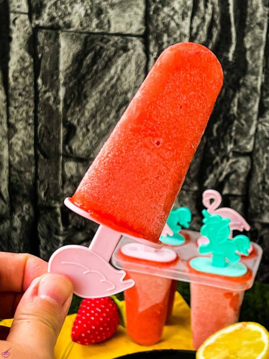 Close-up of a strawberry popsicle on flamingo popsicle stick.