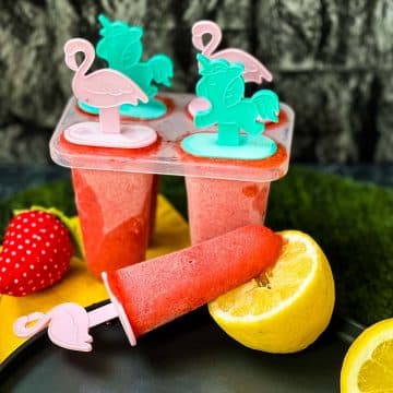 A popsicle mold filled with delicious strawberry ice and cute popsicle sticks inserted