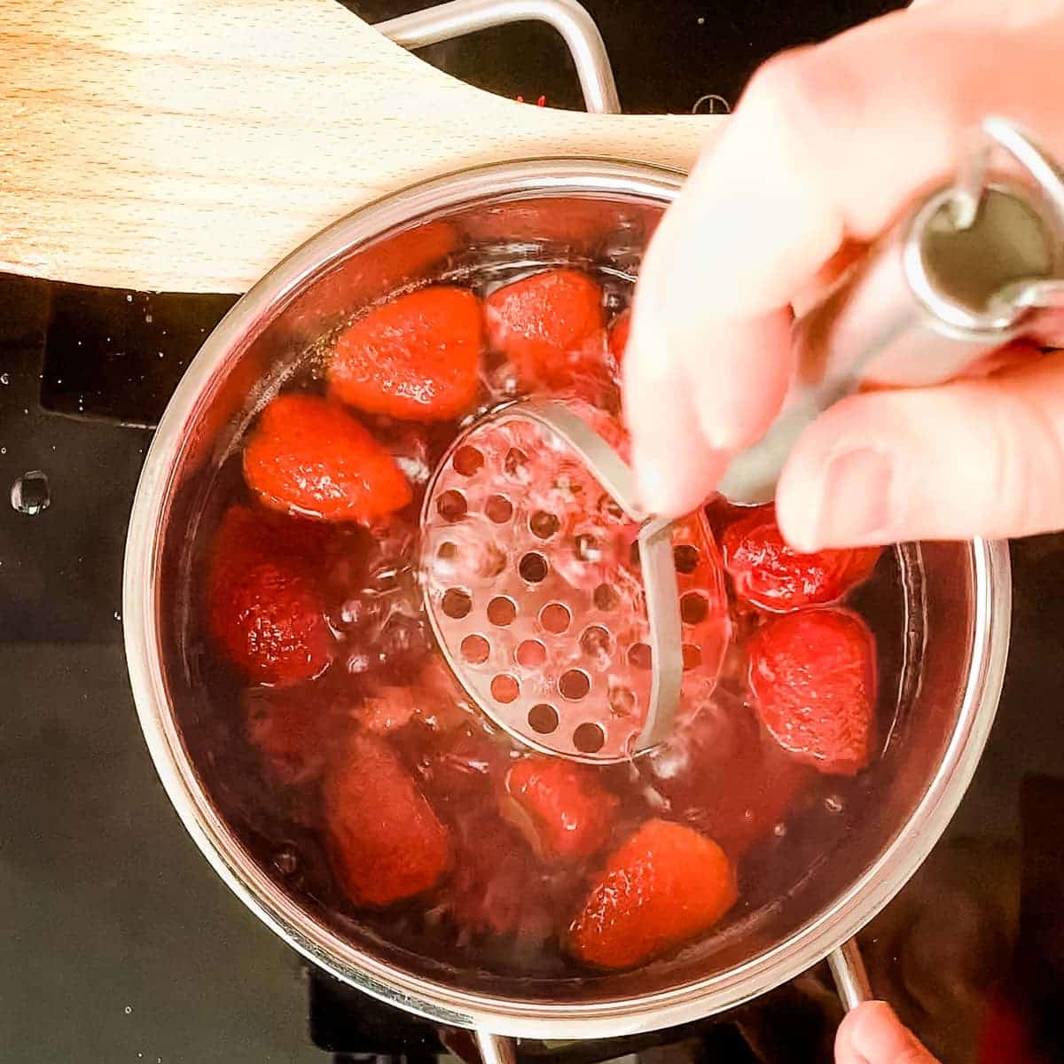 Crush the strawberries with a potato masher.