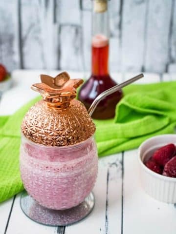 Delicious creamy strawberry milkshake with only four ingredients in a beautiful pineapple-shaped cocktail glass.