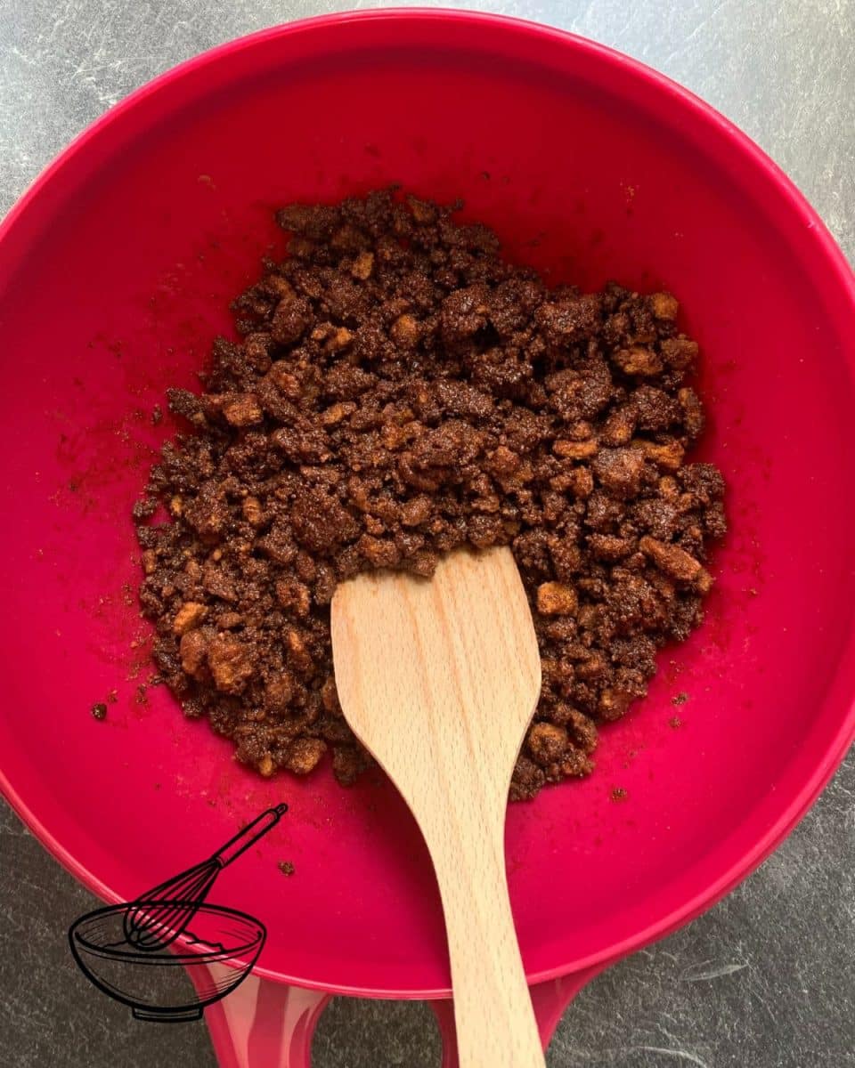 Combine the crushed Biscoff cookies with melted butter and cocoa powder.