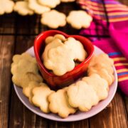 Delicious sugar cookies, placed on pretty plates on dark wooden background.
