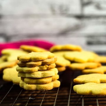 Gorgeous sugar cookies stacked beautifully on a cooling rack.