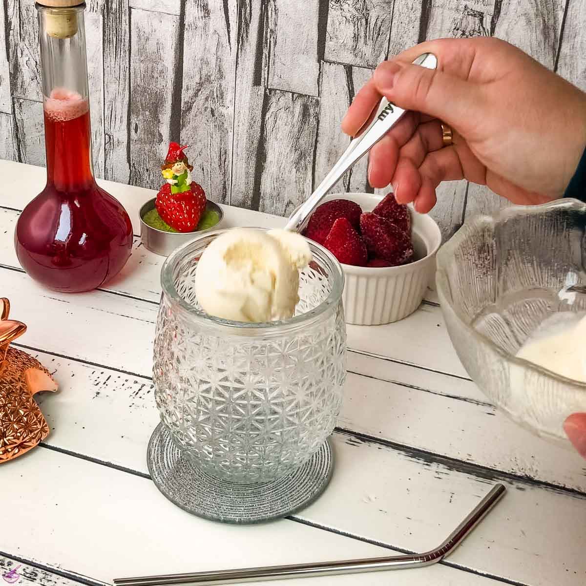 Add two scoops of vanilla ice cream to the cocktail glass.