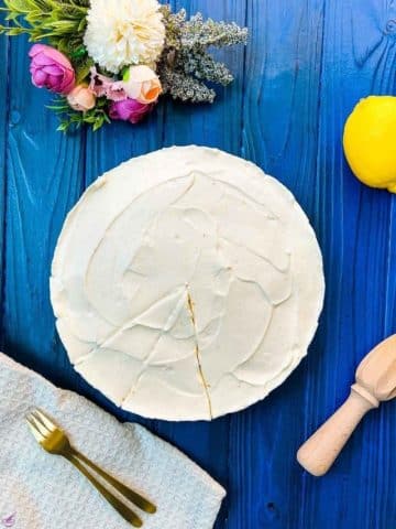 Refreshing lemon cheesecake on dark blue wooden background.