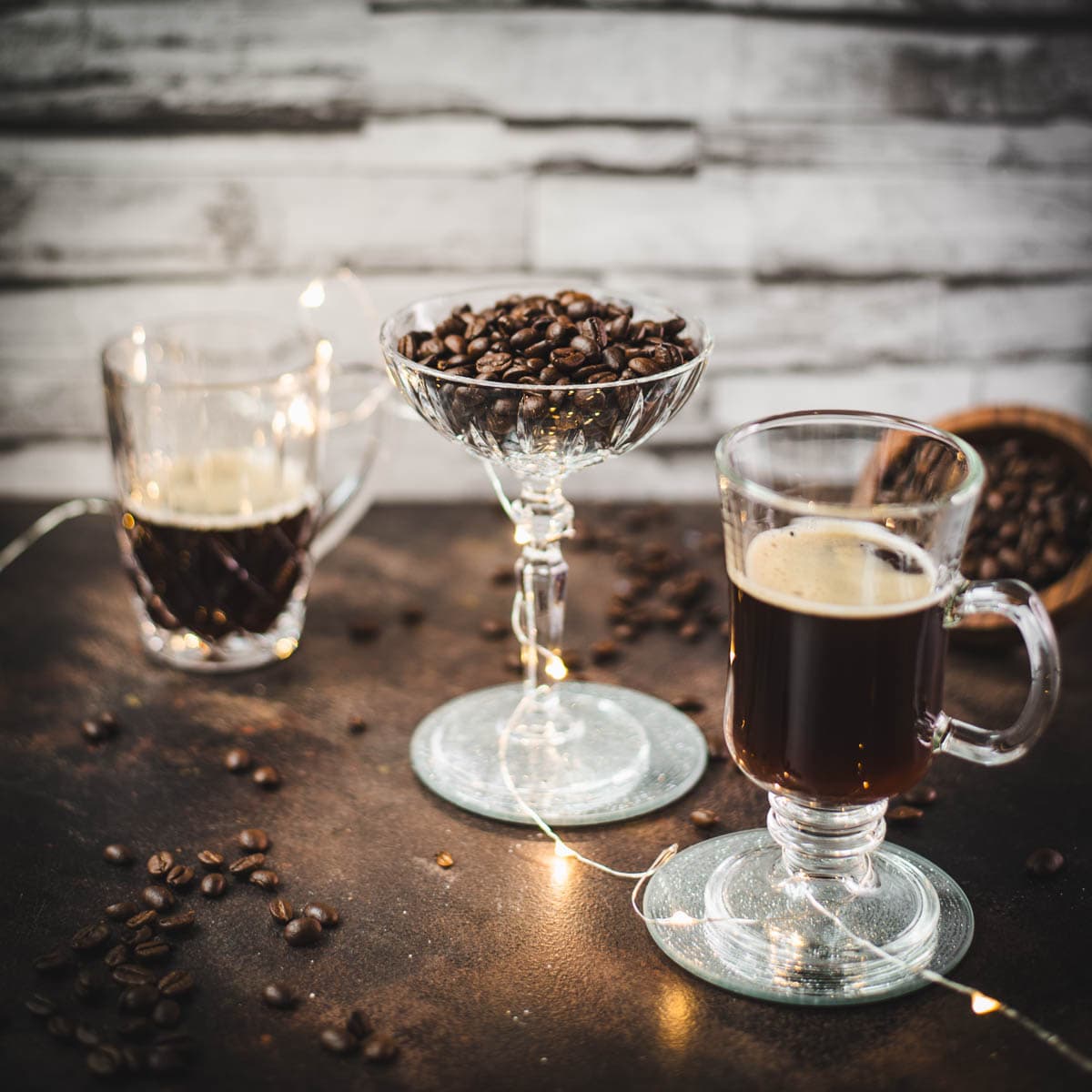 Three gorgeous glasses. Two filled with coffee, centered on filled with coffee beans.