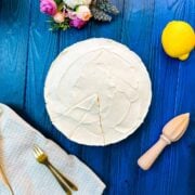 Refreshing lemon cheesecake on dark blue wooden background.