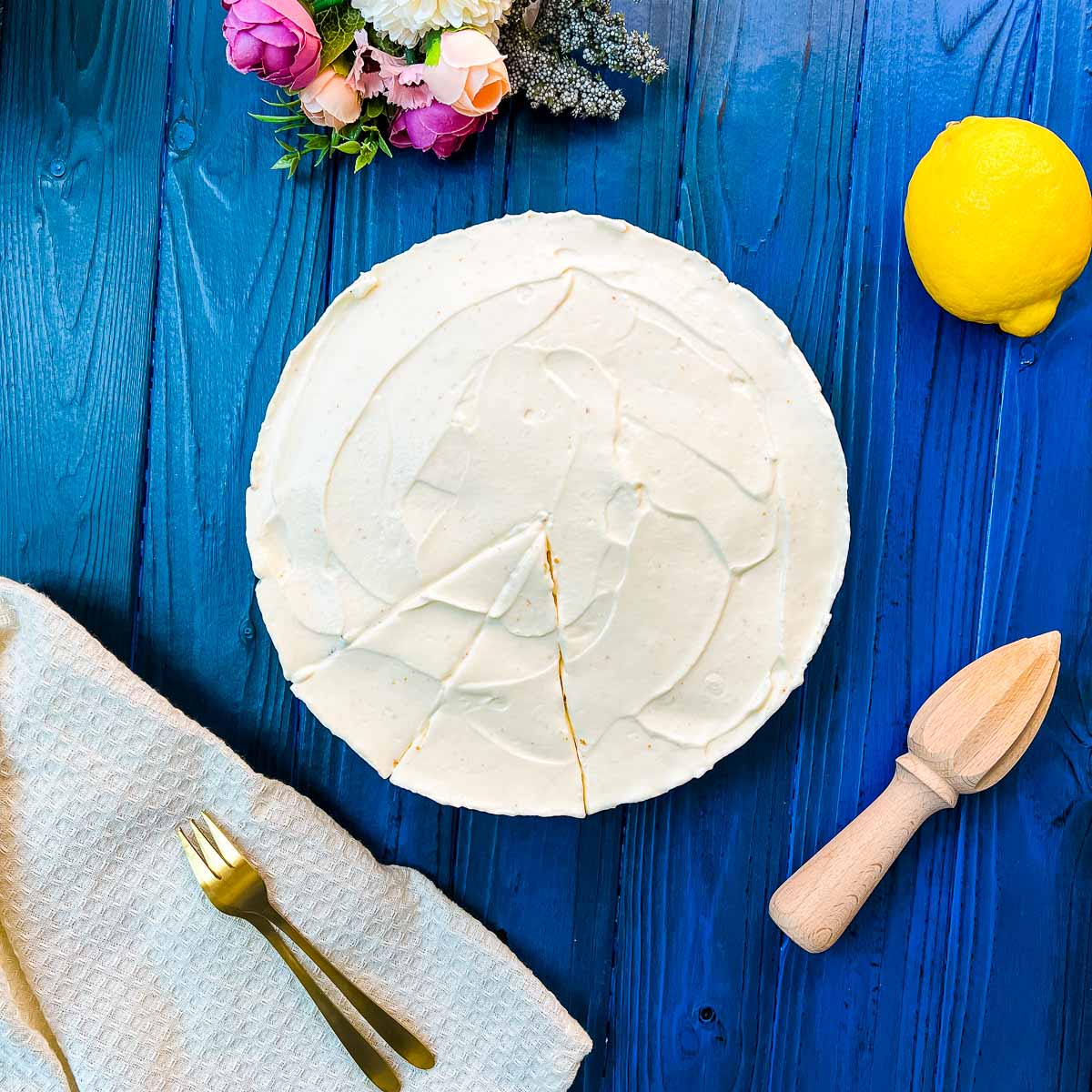 Refreshing lemon cheesecake on dark blue wooden background.
