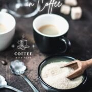 Two coffee mugs, a cup filled with brown sugar, and a glass filled with brown sugar cubes. All placed on dark ground.