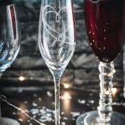 A variety of gorgeous wine, sparkling wine, and collins glasses placed in dark room.