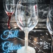 A variety of gorgeous wine, sparkling wine, and collins glasses placed in dark room.