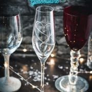 A variety of gorgeous wine, sparkling wine, and collins glasses placed in dark room.