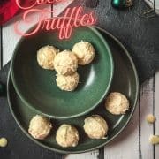 Charming coconut truffles in green bowl next to Christmas decoration.