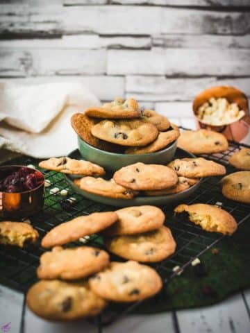 Delicious cookies, packed with dried cranberries and white chocolate chips, placed on cooling rack.